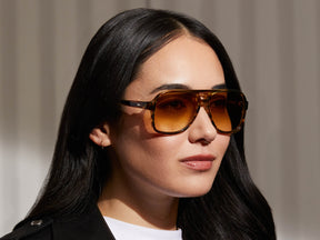 Model is wearing The SHEISTER SUN in Bamboo in size 57 with Chestnut Fade Tinted Lenses