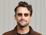 Model is wearing The SHMOOZ SUN in Gold in size 48 with Forest Wood Tinted Lenses
