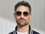 Model is wearing The SHTARKER in size 54 in Gold with Forest Wood Tinted Lenses
