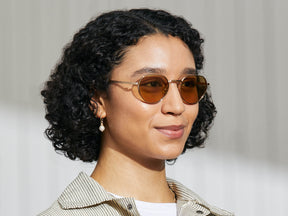 Model is wearing The SMENDRIK SUN in Gold in size 51 with Amber Tinted Lenses