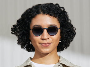 Model is wearing The SMENDRIK SUN in Navy in size 51 with Denim Blue Tinted Lenses