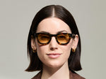 Model is wearing The TELENA  in Tortoise/Black in size 44 with Chestnut Fade Tinted Lenses