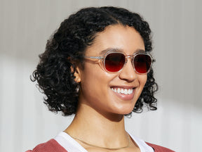 Model is wearing The YENEM SUN in Crystal in size 50 with Cabernet Tinted Lenses