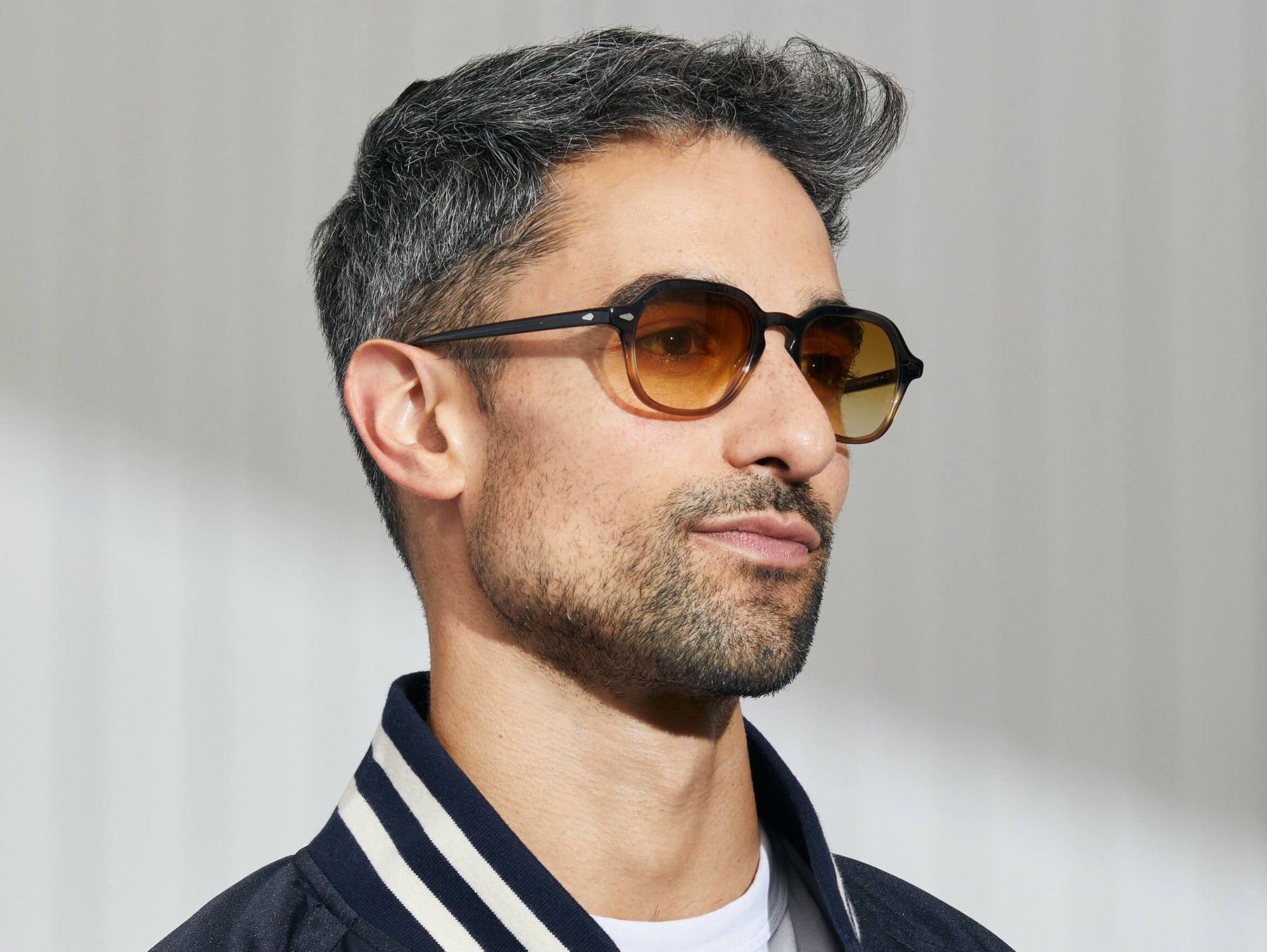 Model is wearing The YENEM SUN in Grey-Brown Fade in size 50 with Chestnut Fade Tinted Lenses