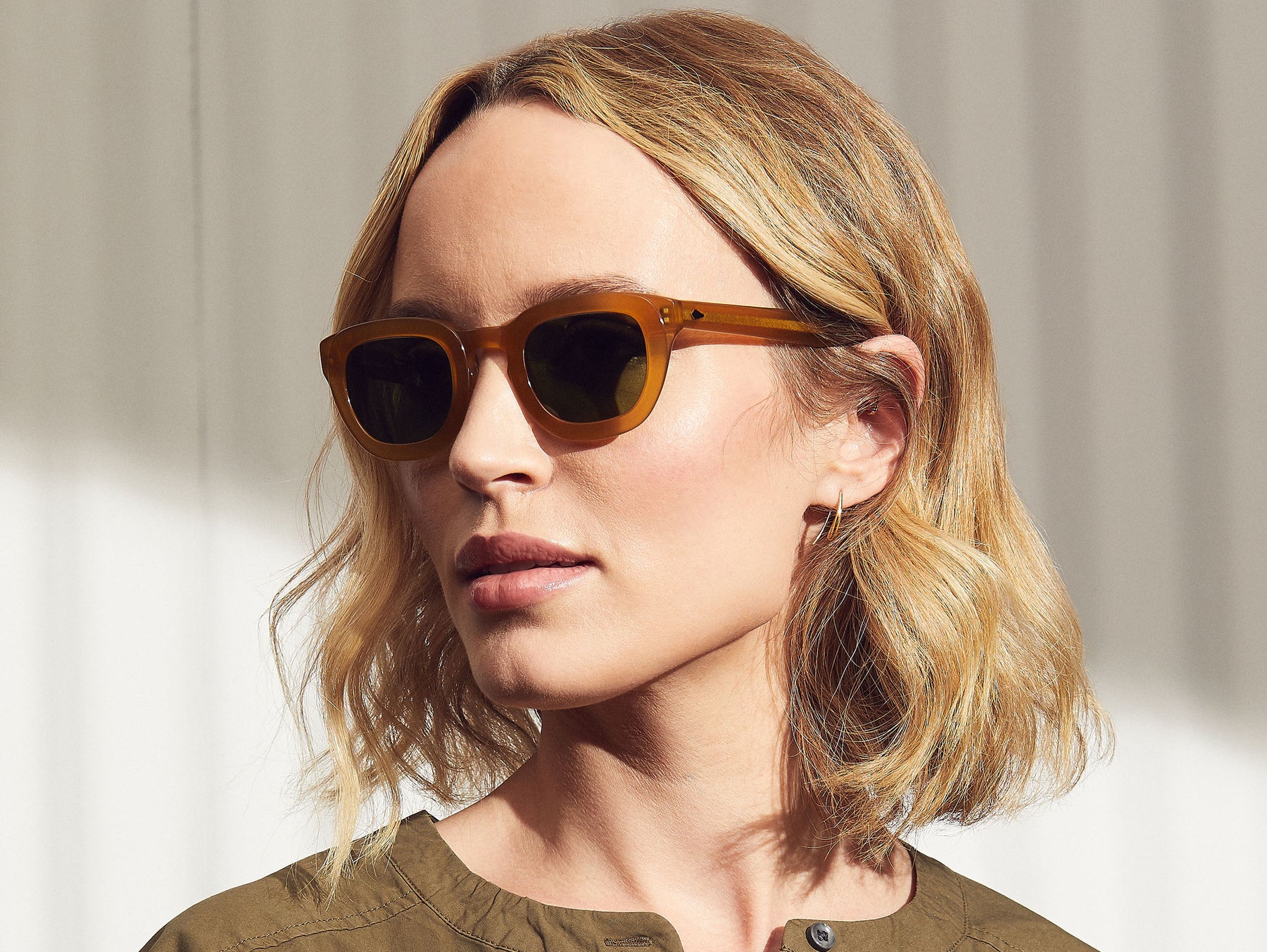 Model is wearing the TELENA SUN in Butterscotch in size 44 with Calibar Green Glass Lenses