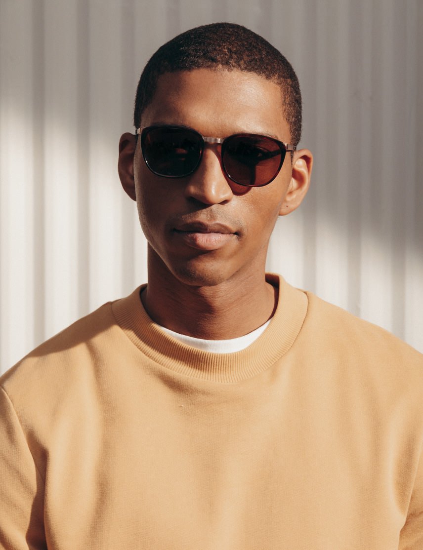 Model is wearing The BRUDE SUN in Burnt Tortoise/Gold in size 51 with Cosmitan Brown Glass Lenses