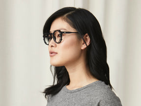 Model is wearing The CLIPZEN in Matte Black in size 49 with Blue Protect Lenses