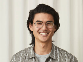 Model is wearing The SCHLEP CLIP in Gold in size 50 with Blue Protect Lenses