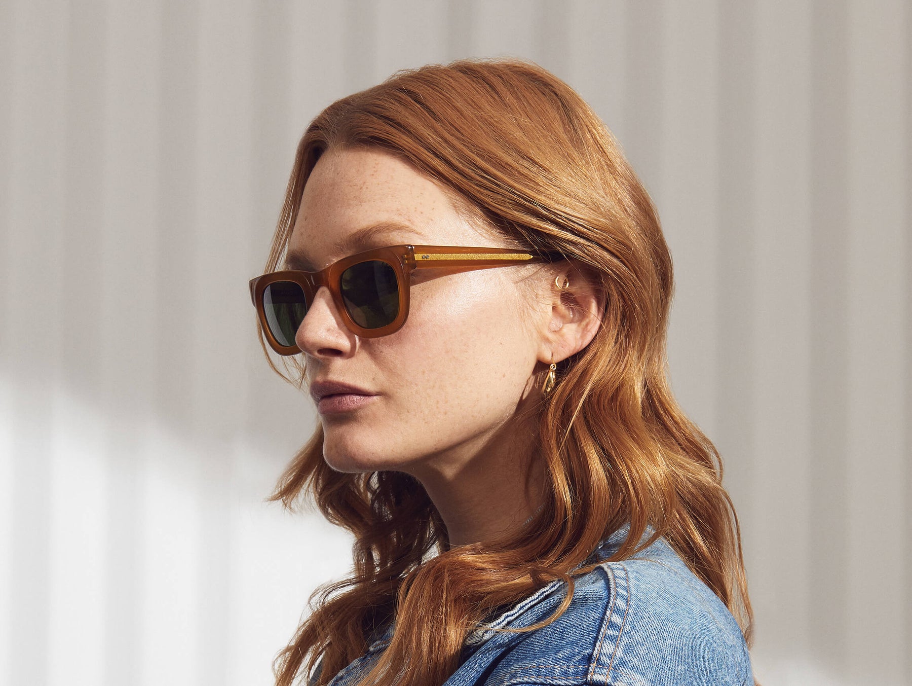 Model is wearing the FRITZ SUN in Butterscotch in size 44 with Calibar Green Glass Lenses