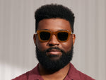 Model is wearing The FRITZ SUN in Butterscotch in size 47 with Calibar Green Glass Lenses