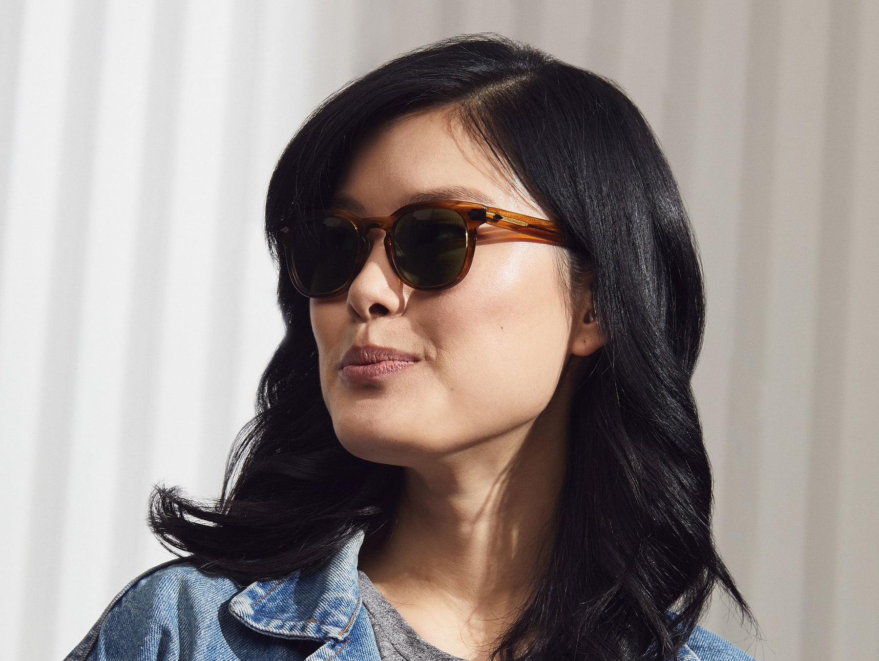 Model is wearing The GELT SUN in Honey Blonde in size 49 with Calibar Green Glass Lenses