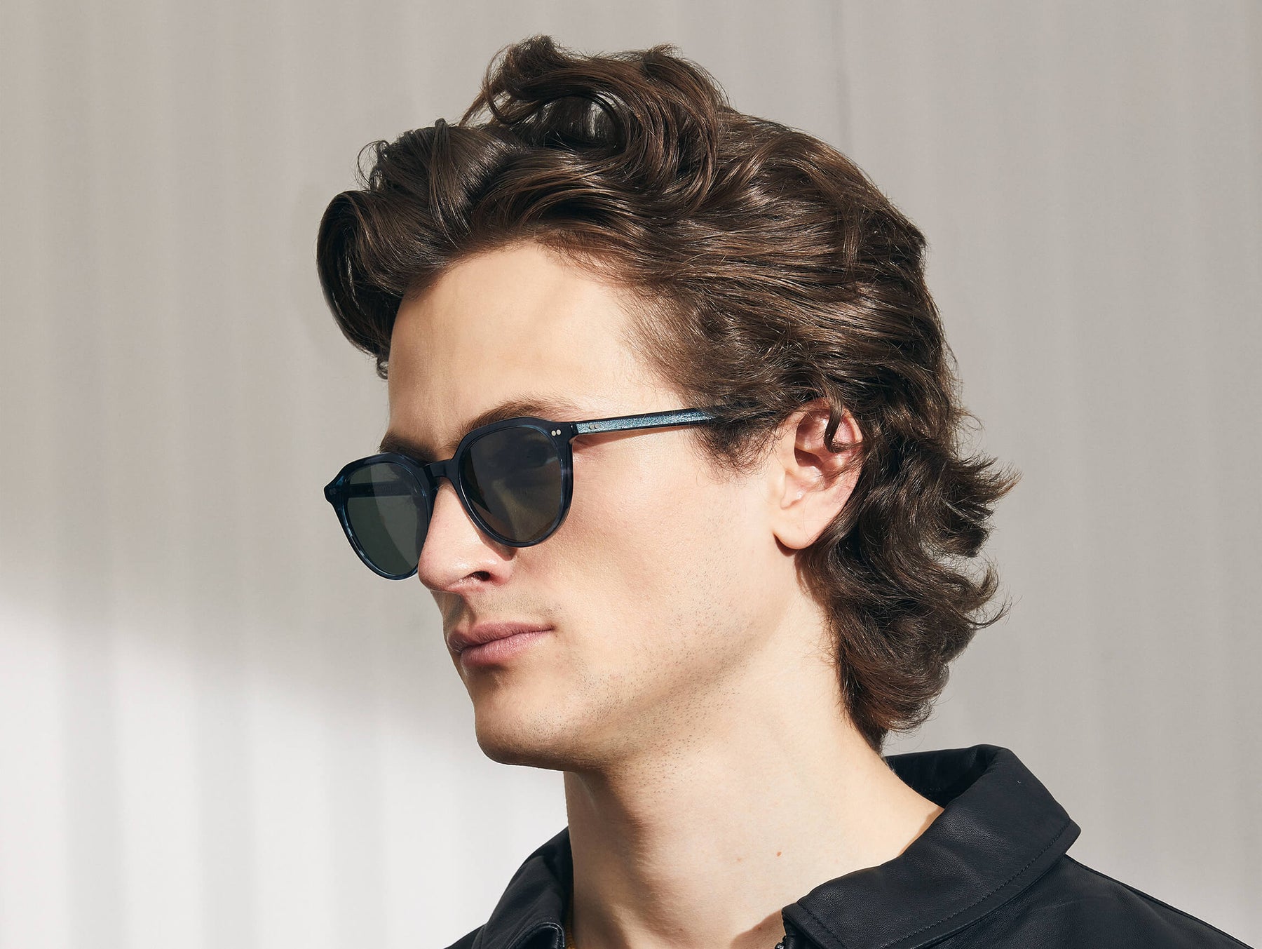 Model is wearing The KITZEL SUN in Ink in size 50 with G-15 Glass Lenses