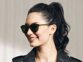Model is wearing The KITZEL SUN in Brown Bamboo in size 50 with Calibar Green Glass Lenses