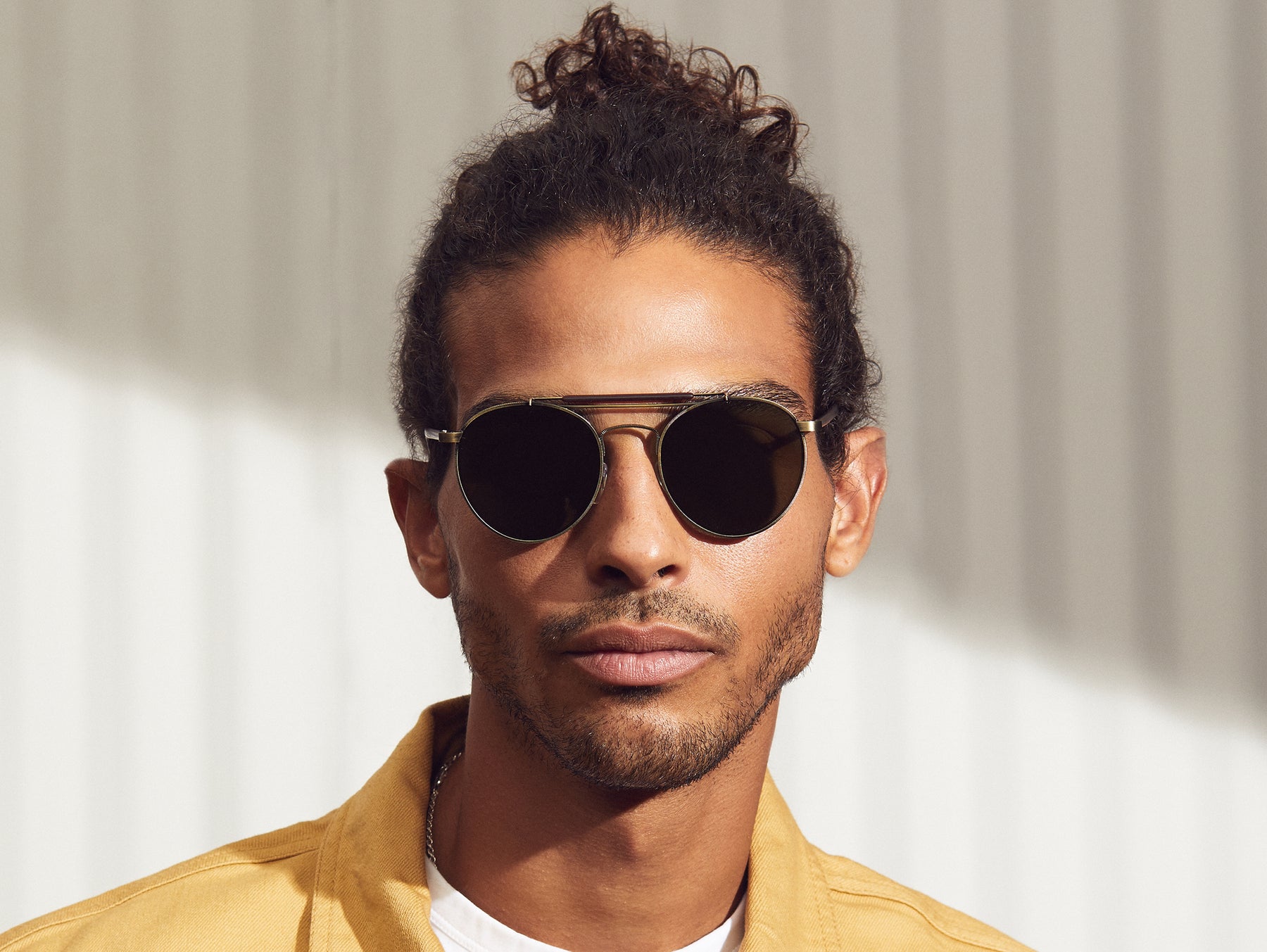 Model is wearing The LAZER SUN in Antique Gold/Matte Dark Brown in size 52 with G-15 Glass Lenses