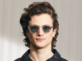 Model is wearing The LEMTOSH-TT in size 46 in Crystal/Gold with Blue Glass Lenses
