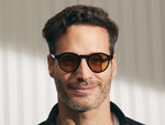 Model is wearing The MILTZEN in Black in size 46 with Amber Tinted Lenses
