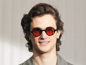 Model is wearing The ZOLMAN in Black in size 42 with Woodstock Orange Tinted Lenses
