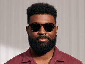 Model is wearing The MOMZA SUN in Tortoise in size 49 with G-15 Glass Lenses