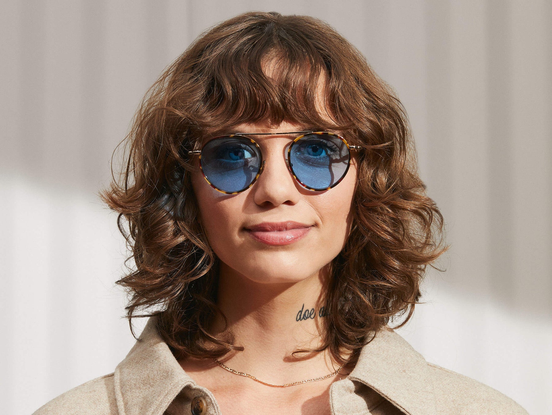 Model is wearing The PUPIK SUN in Tortoise/Gold in size 47 with Celebrity Blue Tinted Lenses