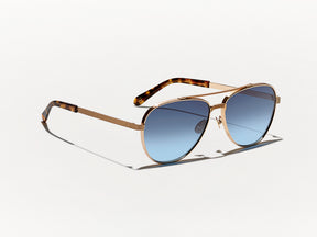 The SHAV SUN in Gold with Denim Blue Tinted Lenses