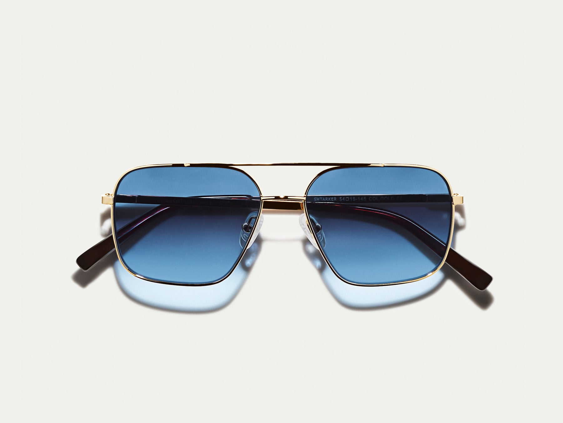The SHTARKER in Gold with Denim Blue Tinted Lenses