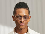 Model is wearing The SHTARKER in size 54 in Gold with Bel Air Blue Tinted Lenses