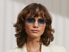 Model is wearing The SHTARKER in size 54 in Gold with Broadway Blue Fade Tinted Lenses