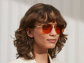 Model is wearing The SHTARKER in size 54 in Gold with Woodstock Orange Tinted Lenses