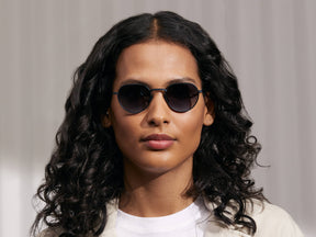 Model is wearing The SMENDRIK SUN in Navy in size 48 with Denim Blue Lenses
