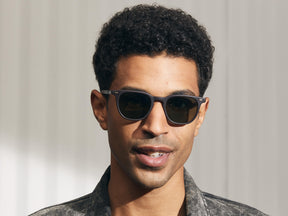 Model is wearing The TATAH SUN in Matte Dark Brown in size 50 with G-15 Glass Lenses