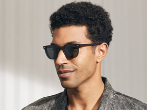 Model is wearing The TATAH SUN in Matte Dark Brown in size 50 with G-15 Glass Lenses