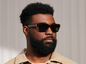 Model is wearing The ZOGAN SUN in Tortoise in size 51 with Green Lenses