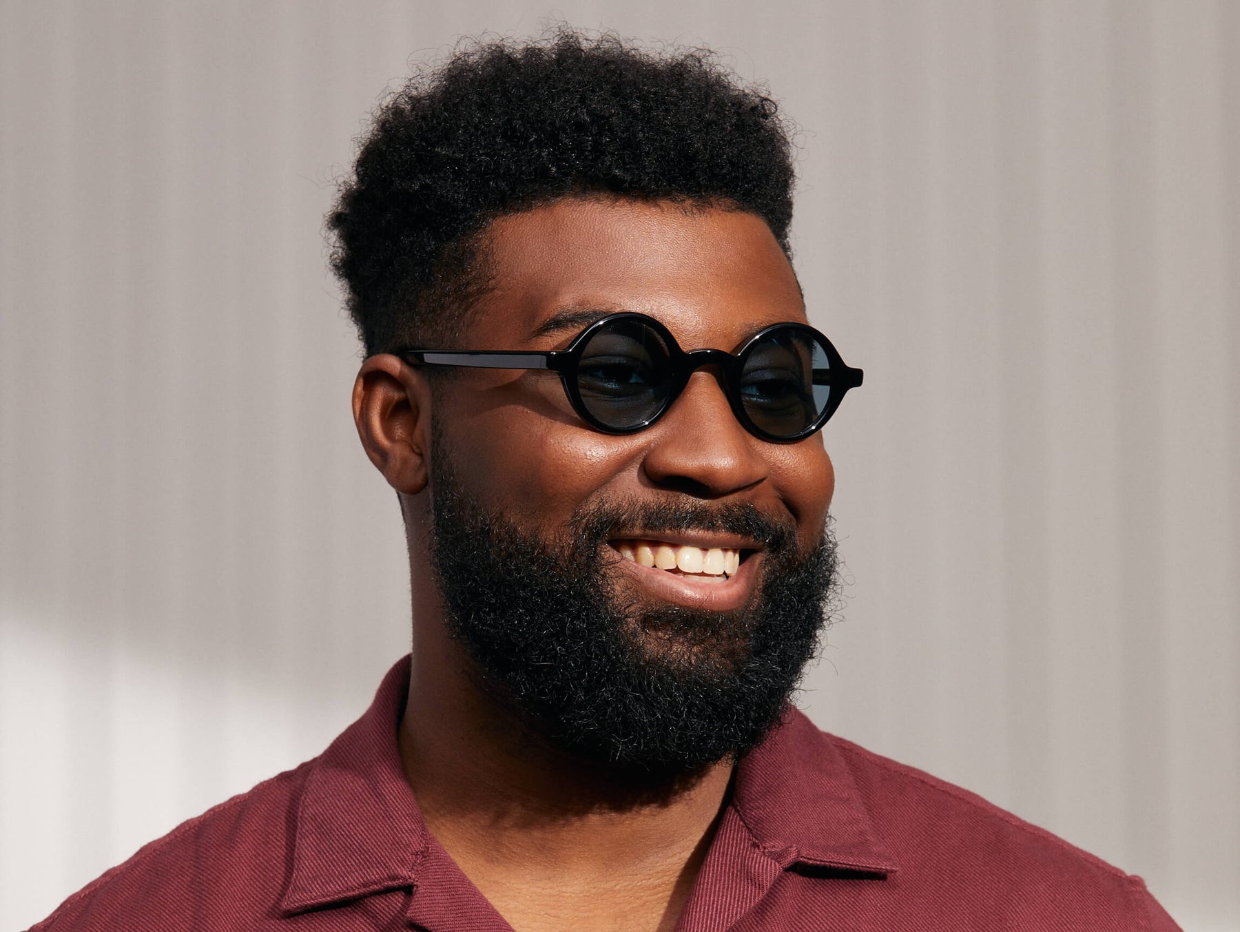 Model is wearing The ZOLMAN SUN in Black in size 42 with Blue Glass Lenses