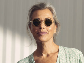 Model is wearing The ZOLMAN SUN in Flesh in size 42 with Calibar Green Glass Lenses