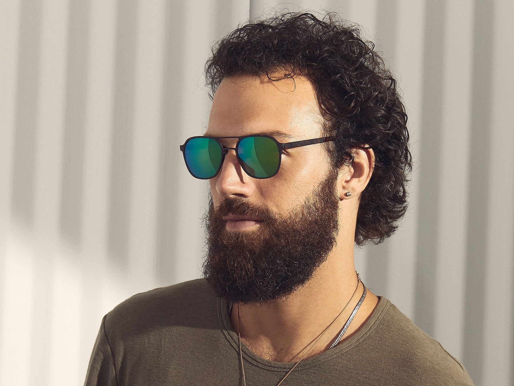 Model is wearing The ZULU-T SUN in Tortoise/Pine in size 54 with Green Flash Mirror Lenses